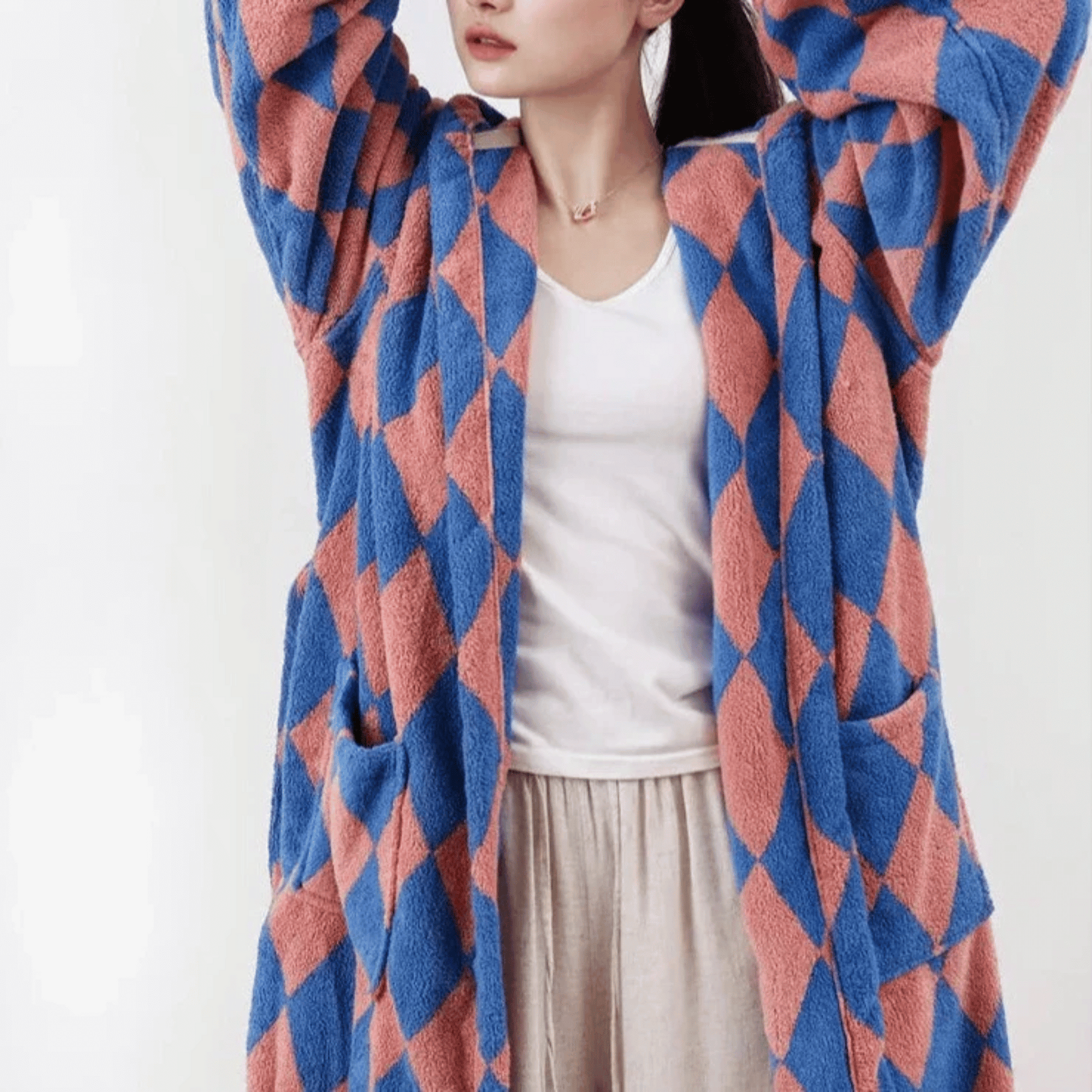 Person wearing a blue and red patterned cardigan on a white background