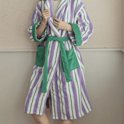 Person wearing a striped robe with green accents against a neutral background