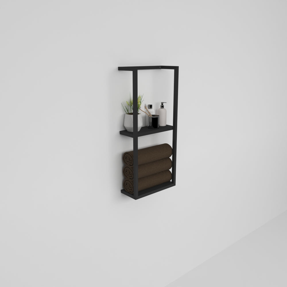 A close-up view of a black floating shelf mounted on a white wall, showcasing neatly stacked towels and small decorative items.