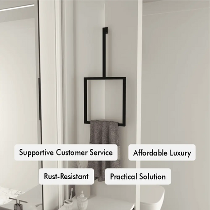 A modern black vertical towel ring is mounted on a white bathroom wall, holding a gray towel.