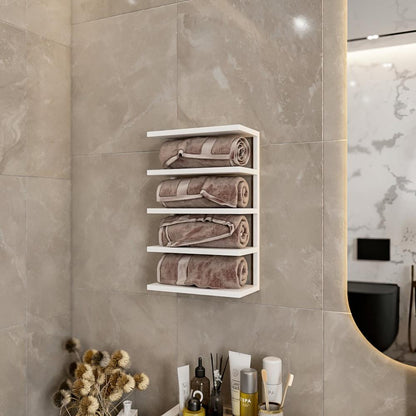 White wall-mounted towel rack in a modern bathroom setting, holding neatly rolled beige towels. The sleek design complements the neutral-toned tile wall and minimalistic decor. Below the rack, a collection of spa essentials and dried flowers add a touch of elegance and functionality
