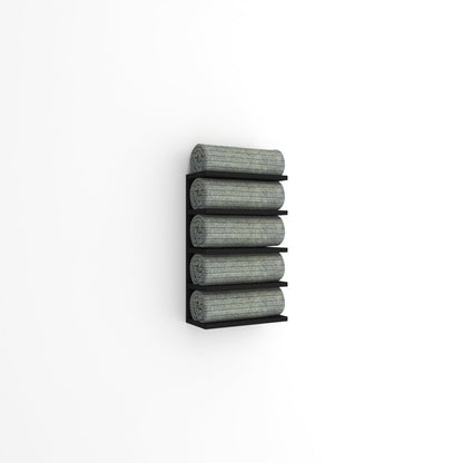 Wall-mounted black towel rack with five tiers, holding rolled green towels against a plain white wall in a minimalist design.