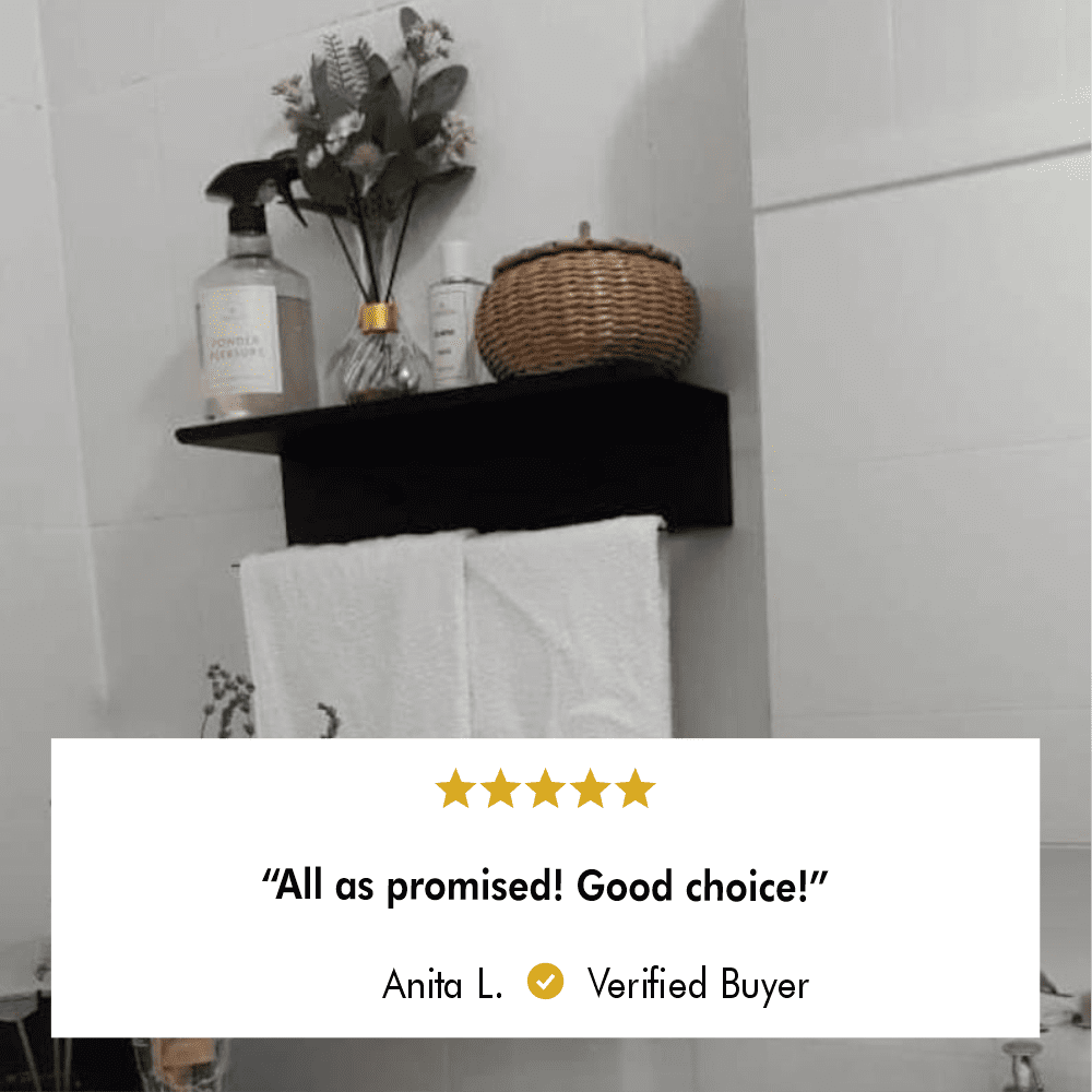 A black wall-mounted towel holder with a shelf, styled with decorative items and a red towel, adding functionality and elegance to a bathroom.